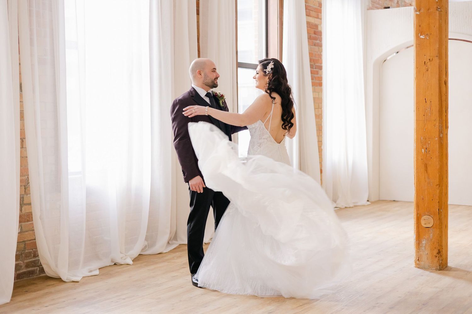 A playful dance moment captured in a modern loft space with natural light.