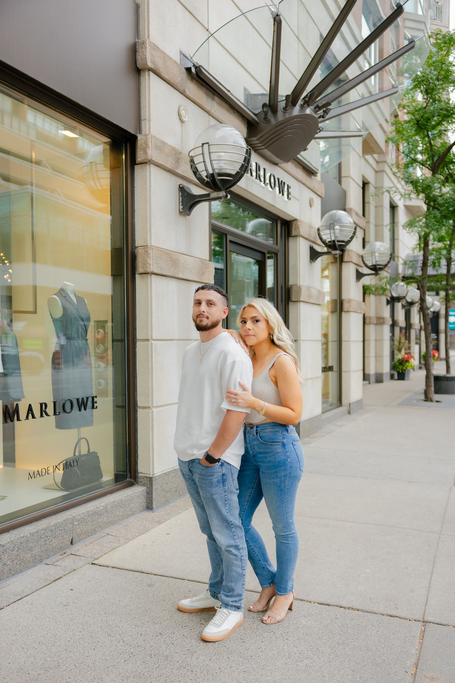 A couple poses outside the Marlowe storefront on a sunny day.