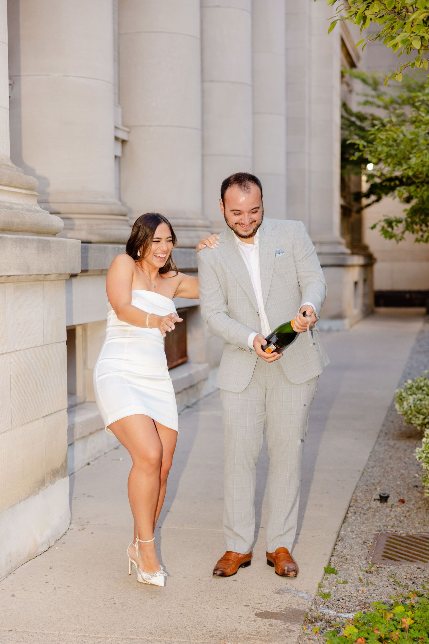 Celebratory champagne moment by elegant stone columns.