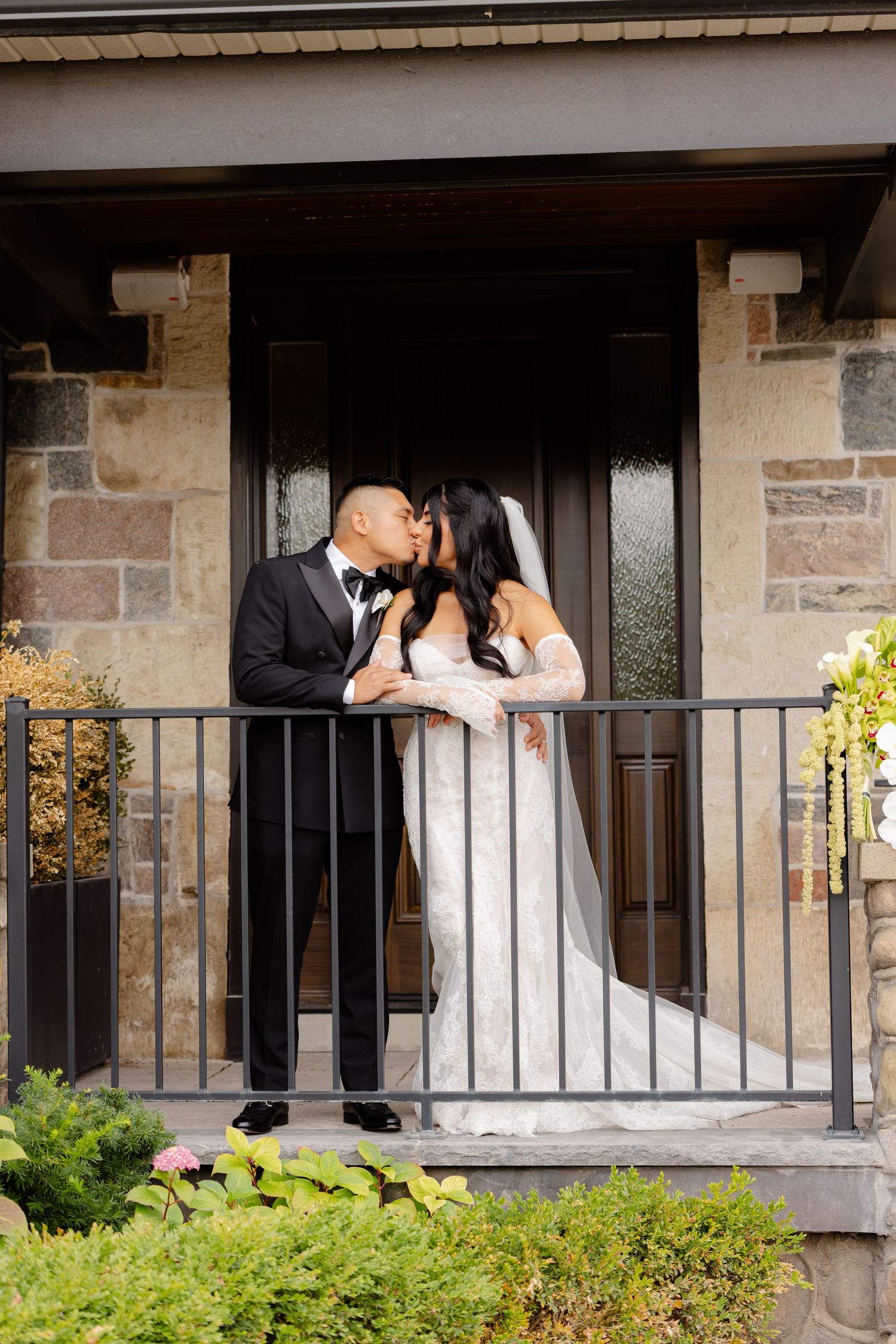 A romantic wedding photoshoot sequence on a stone balcony with decorative railing and greenery in the background.