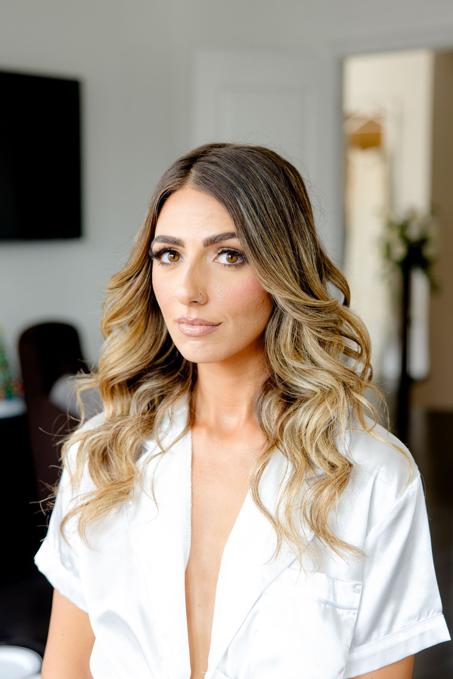 Bridal getting ready portrait in a white robe with professionally styled hair.