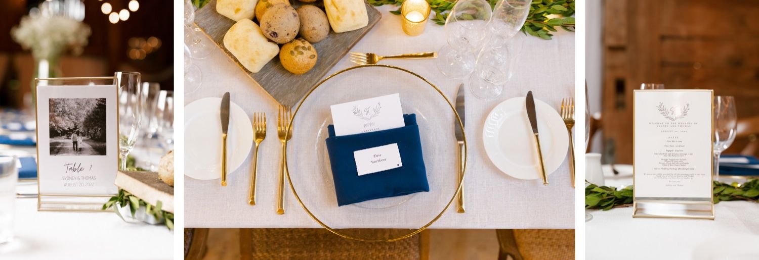 Wedding place setting with gold charger plate, blue napkin, and simple white decor.