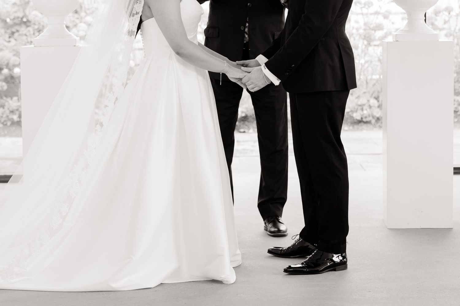 Black and white detail shot of wedding couple's feet during ceremony.