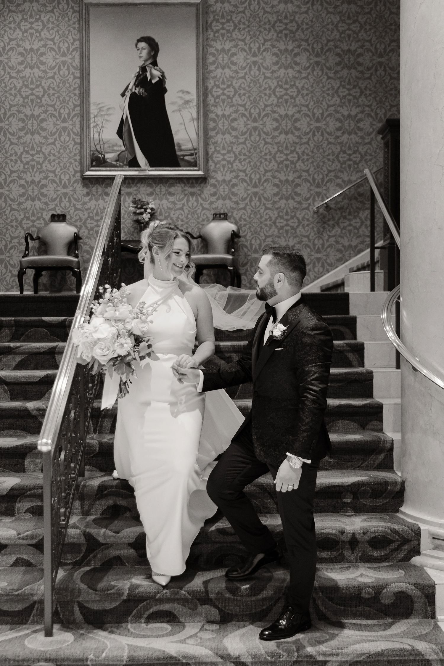 A series of black and white photos showing a playful moment between a bride and groom on a staircase.