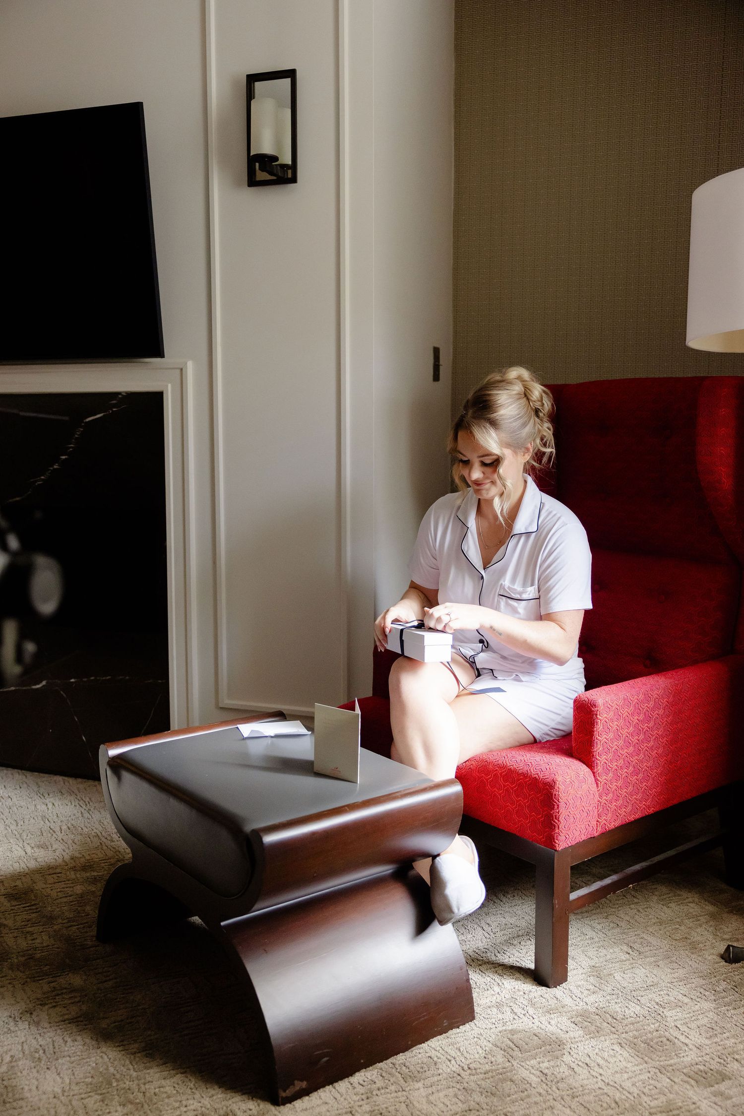 Person in white sitting on red couch in quiet room.