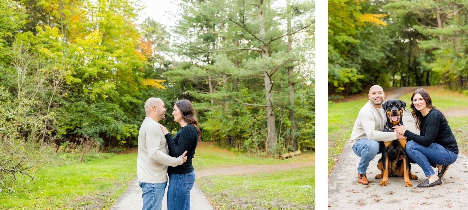 A couple poses with their dog in a wooded area during autumn.