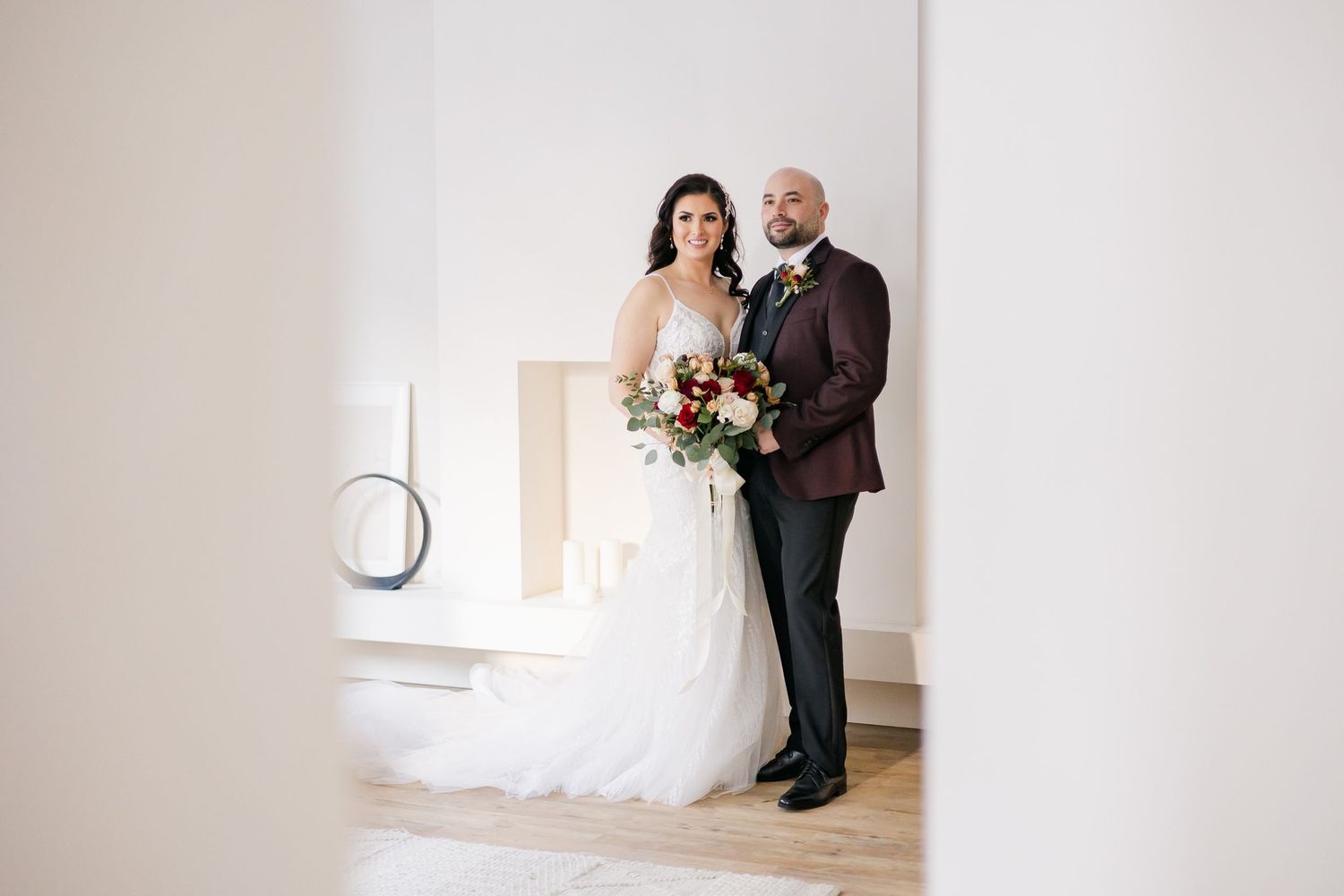 Modern wedding portrait with elegant decor and clean white walls as backdrop.