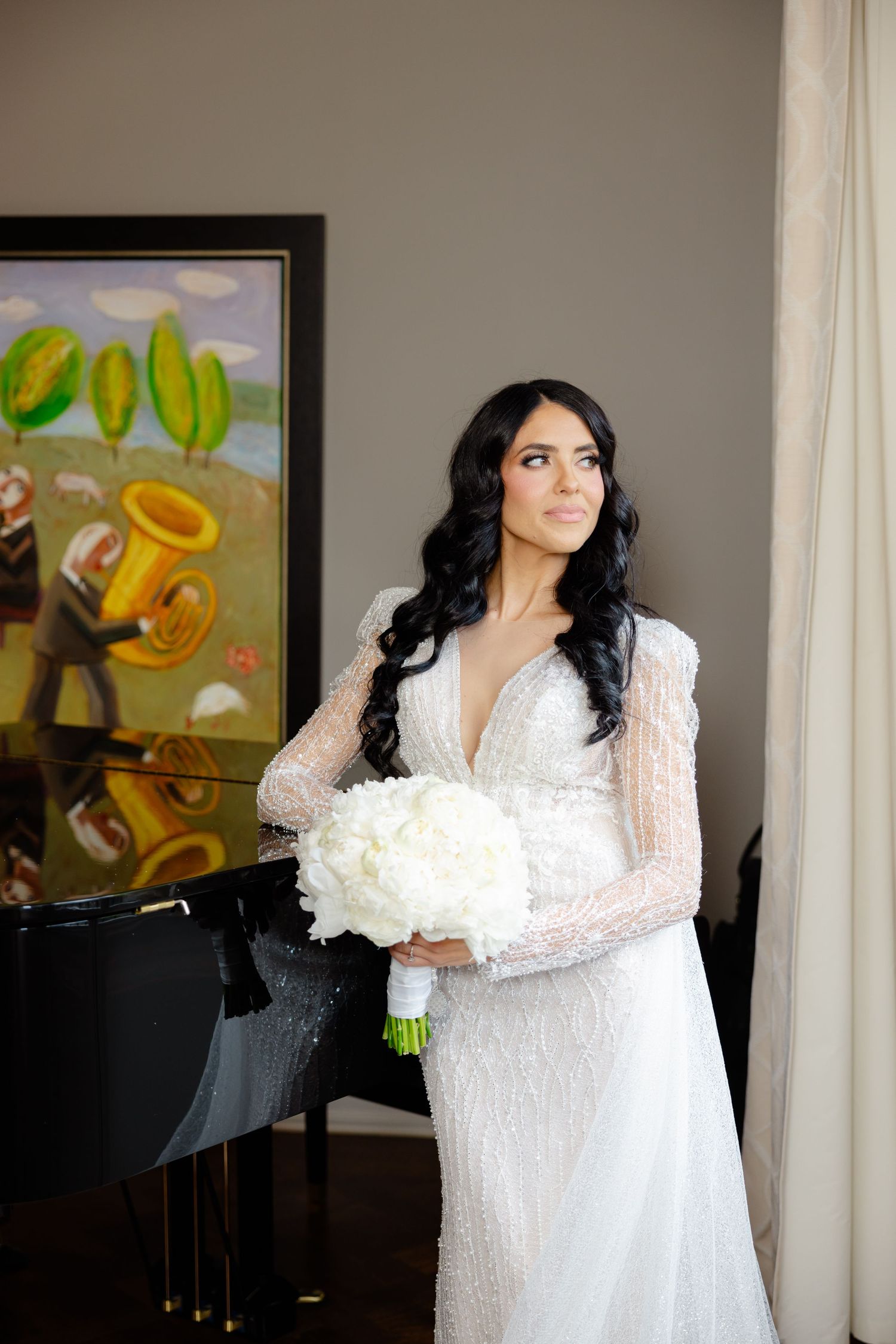 Sophisticated bridal portrait in front of piano and colorful modern artwork.