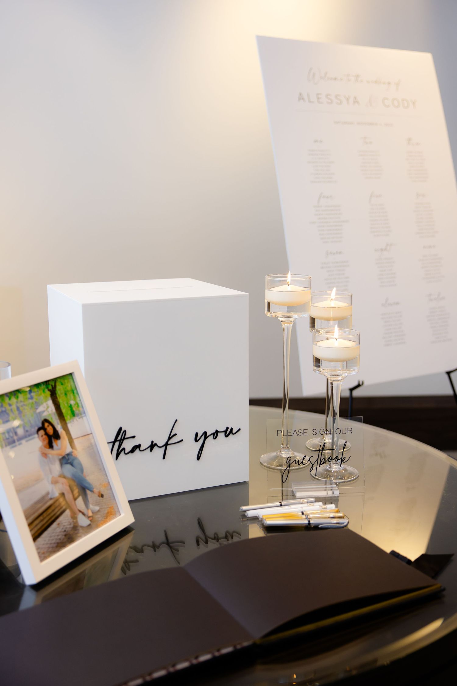 Wedding reception detail showing seating chart, thank you cards, and decorative candle holders.
