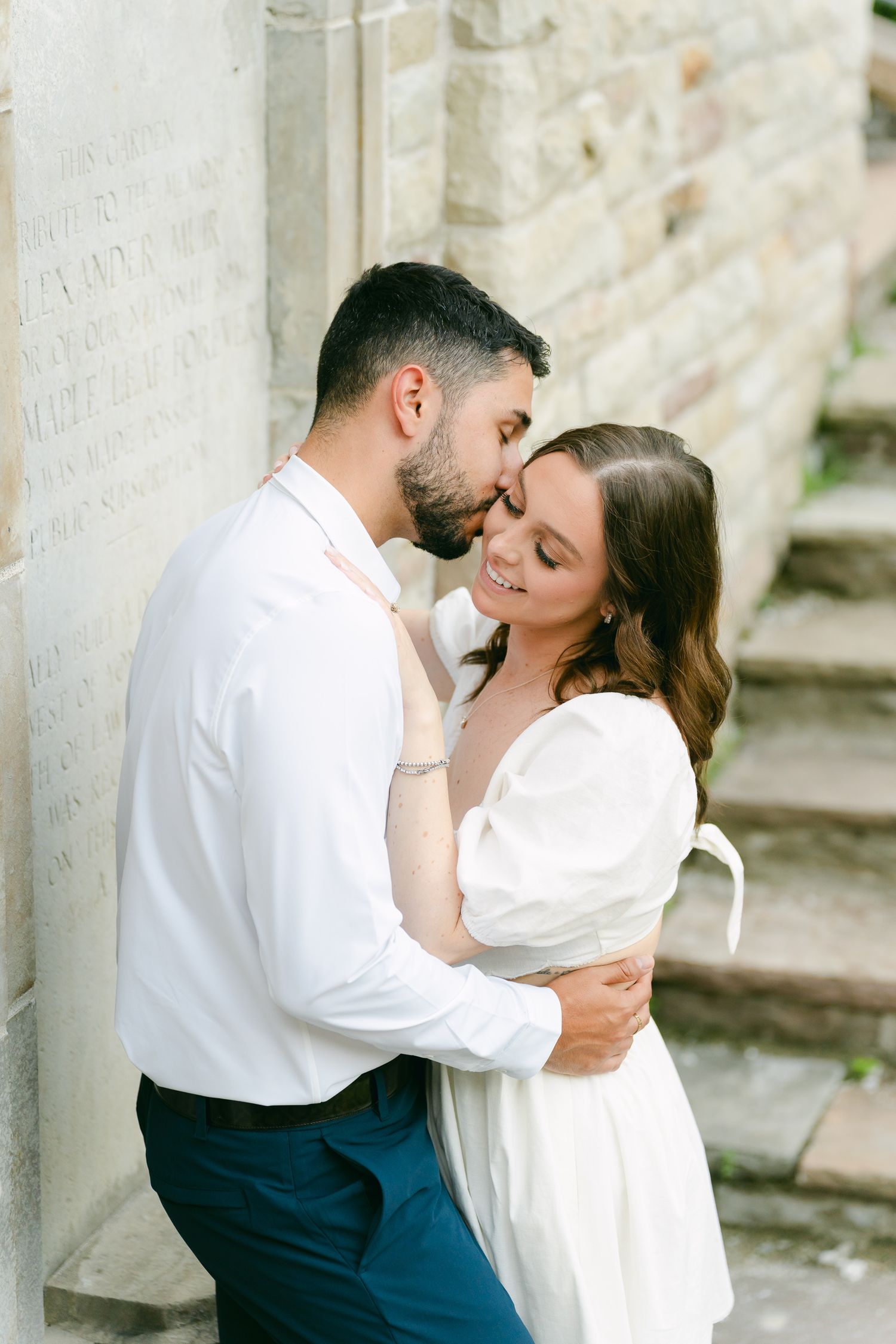 An intimate moment shared between a couple in white and navy blue attire.