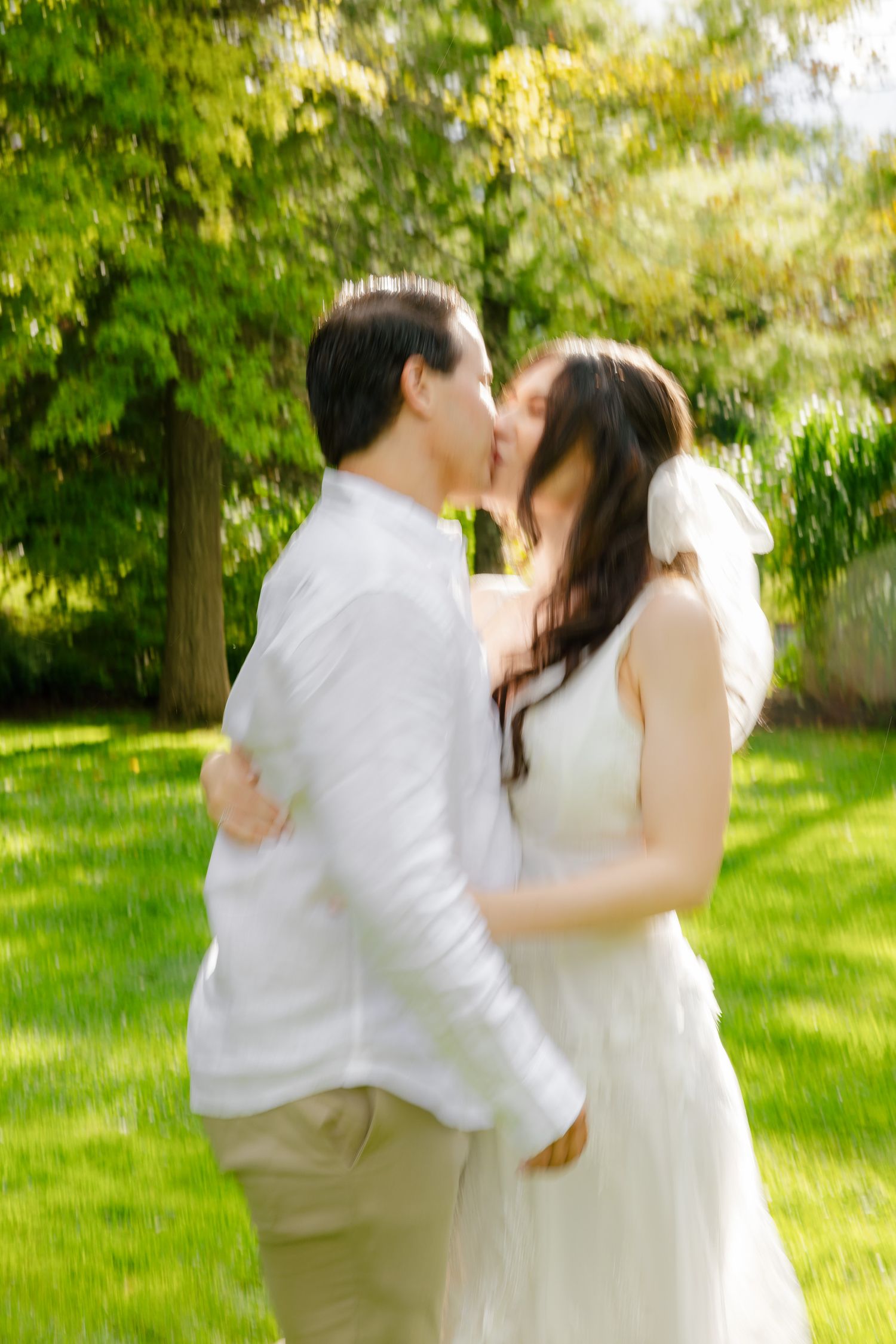 A romantic wedding couple shares a kiss in a lush garden setting on their special day.