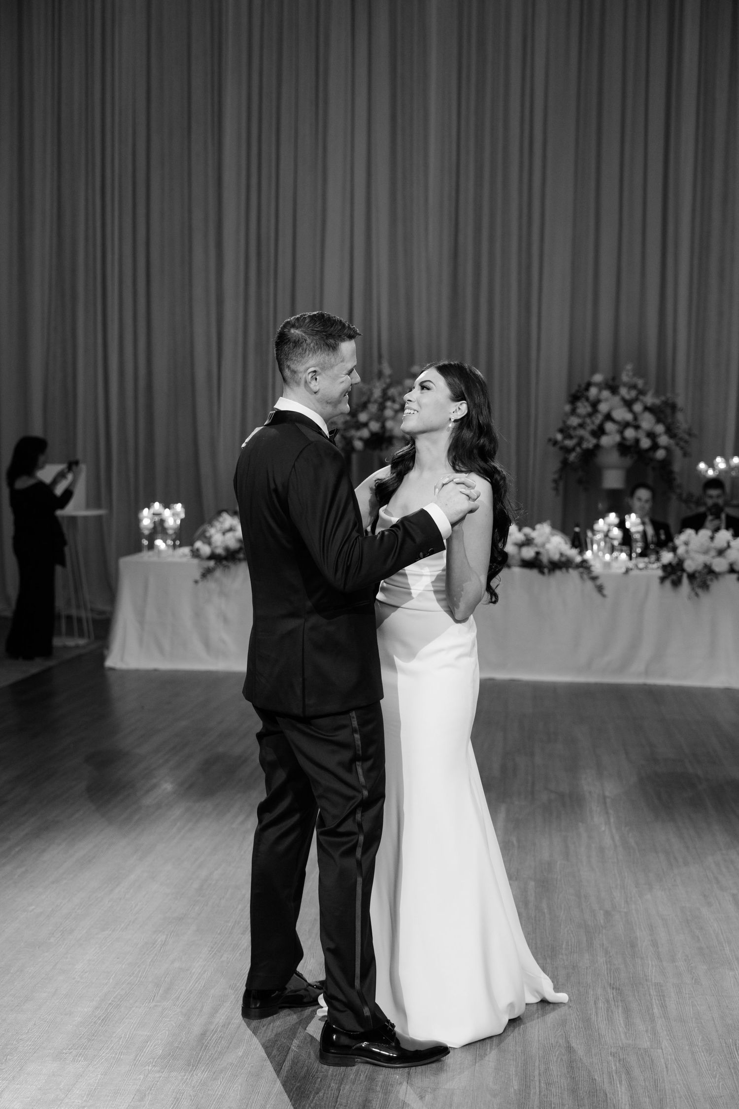 A romantic black and white portrait of a couple during their first dance at their wedding reception.