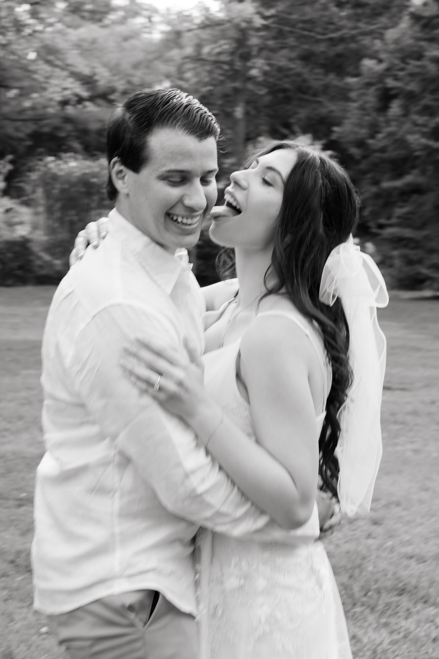 A candid black and white photo capturing genuine laughter between a couple during their photoshoot.