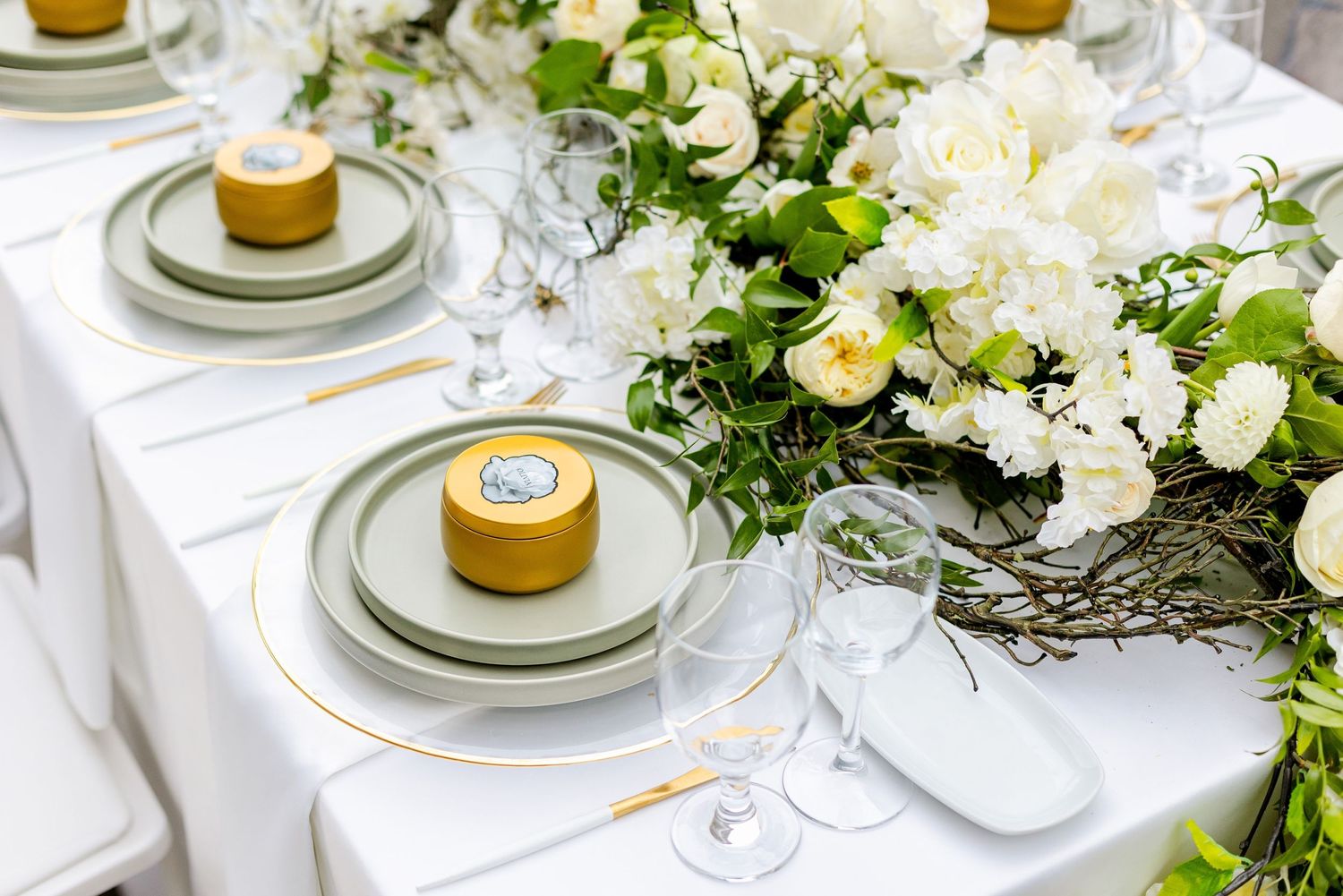 Luxurious table setting with yellow desserts and white flower arrangements at wedding reception.