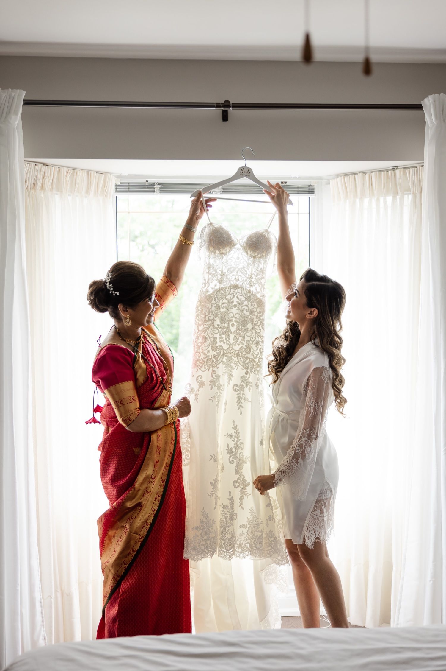 Wedding dress being hung in window as preparations begin on wedding morning.