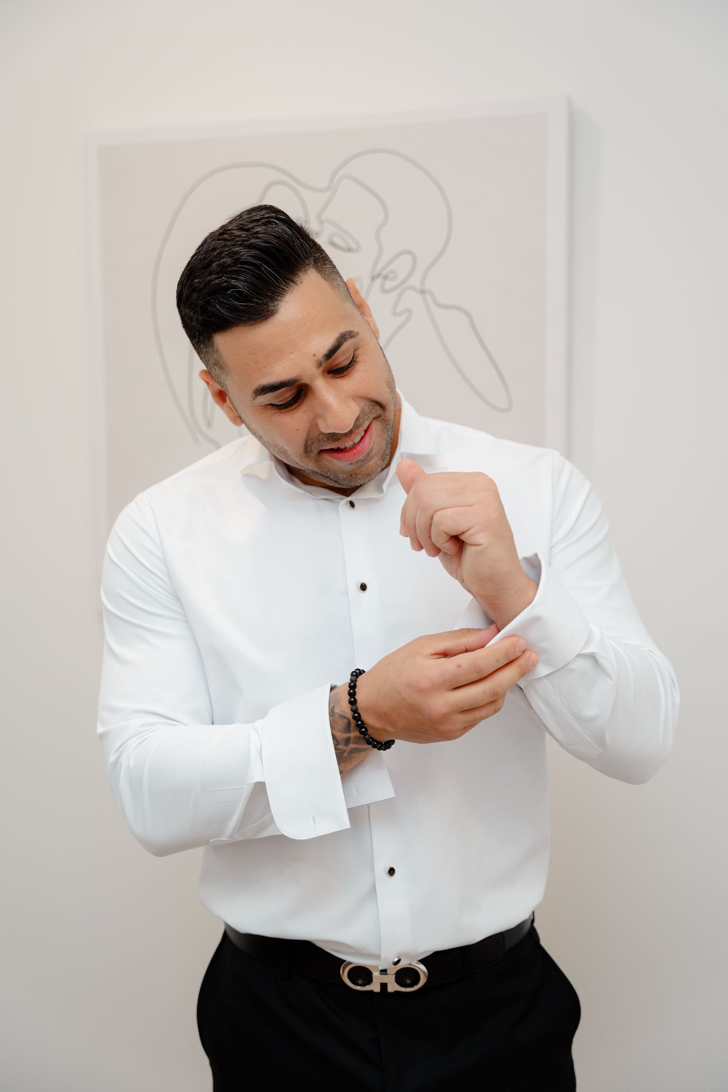 Someone adjusting white dress shirt cuff while getting ready.