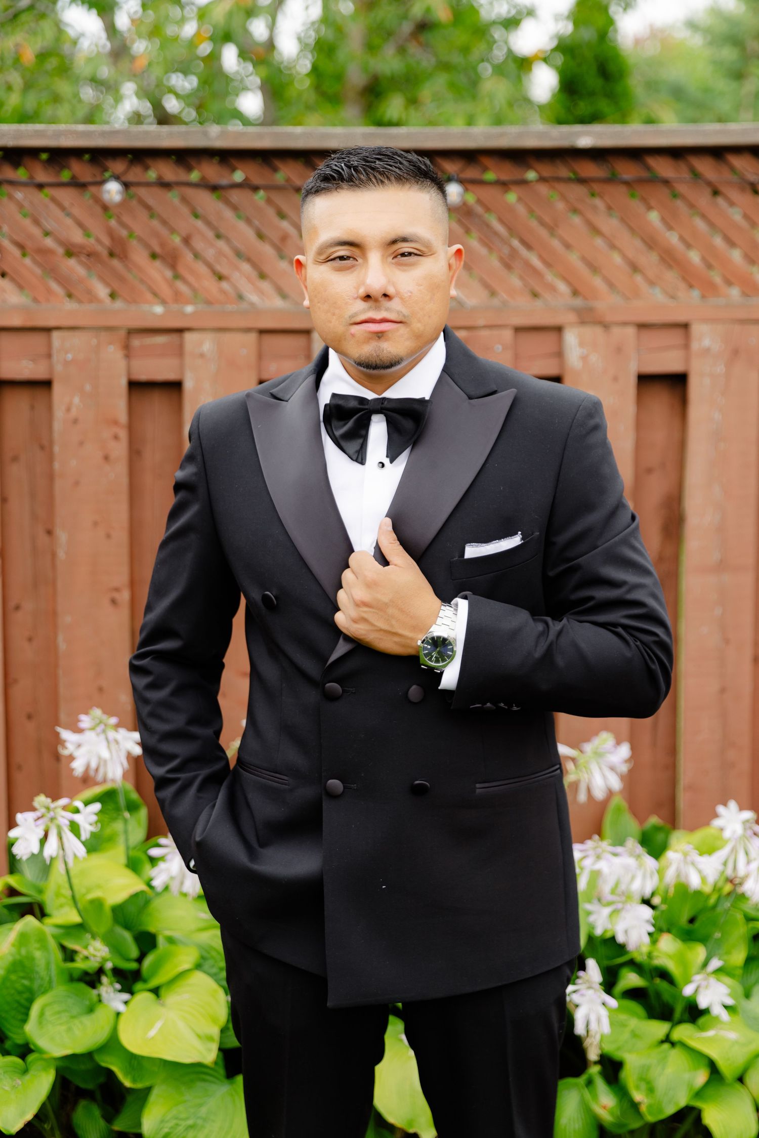 A series of formal portraits showing a person in a black tuxedo and white bowtie against a wooden fence and garden backdrop.