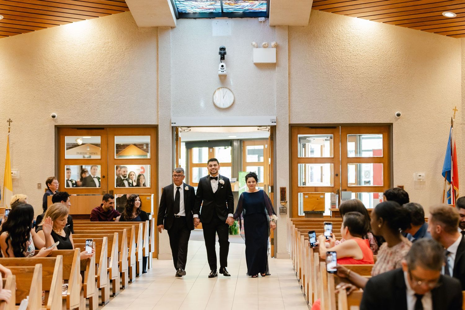Wedding ceremony in progress inside church sanctuary with wooden pews.