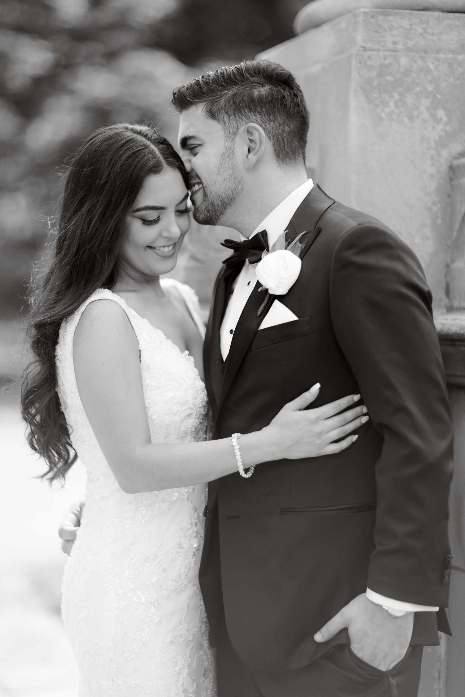 Intimate black and white portrait of bride and groom sharing a tender moment.