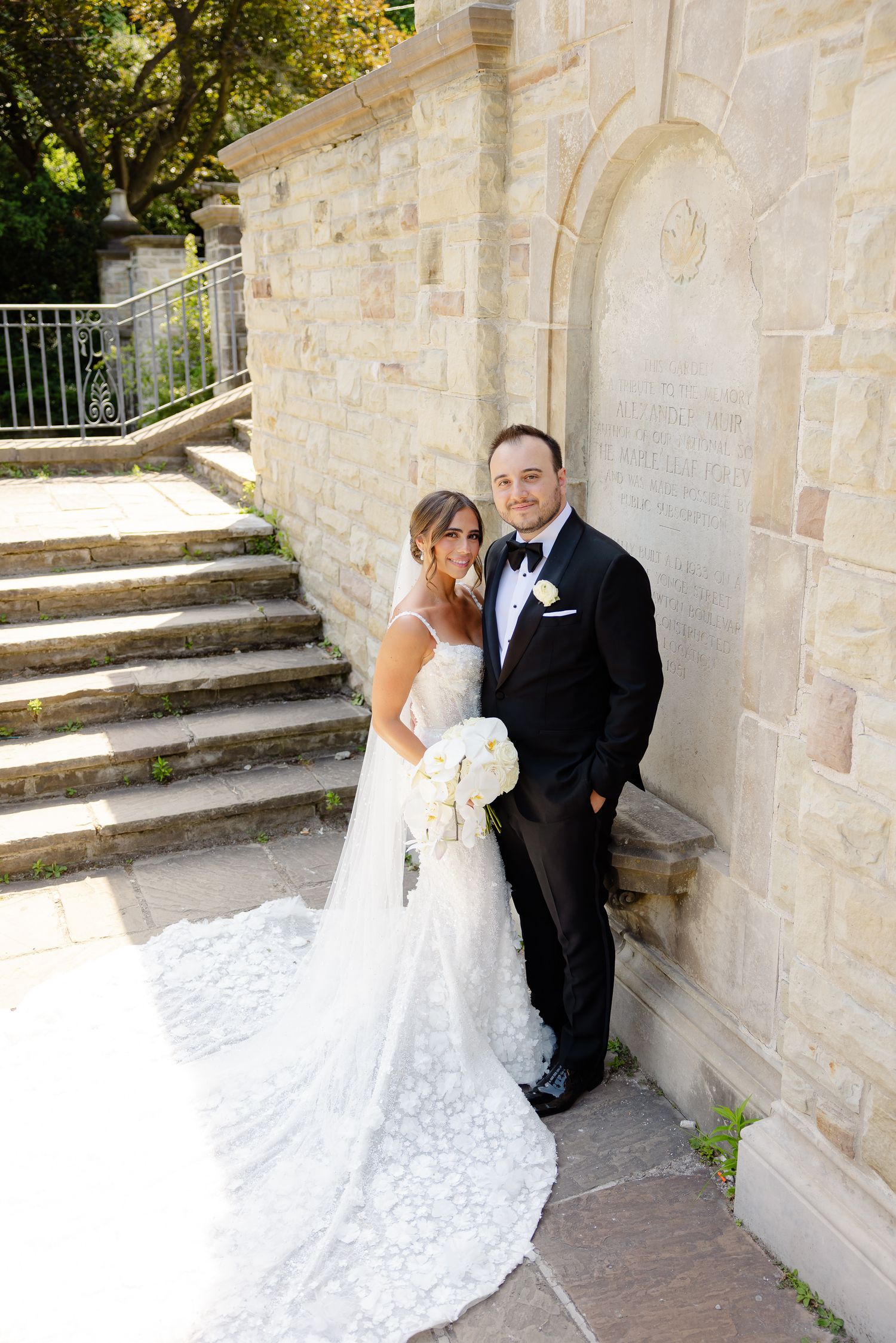 Scenic wedding portrait series of bride and groom posing against stone walls and steps.