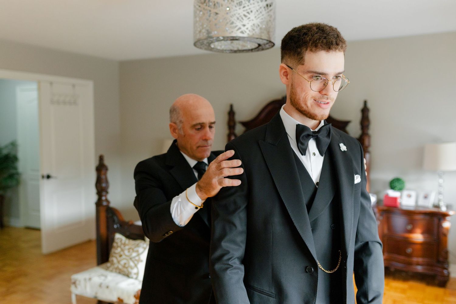 Final touches being made to a formal black tuxedo outfit.