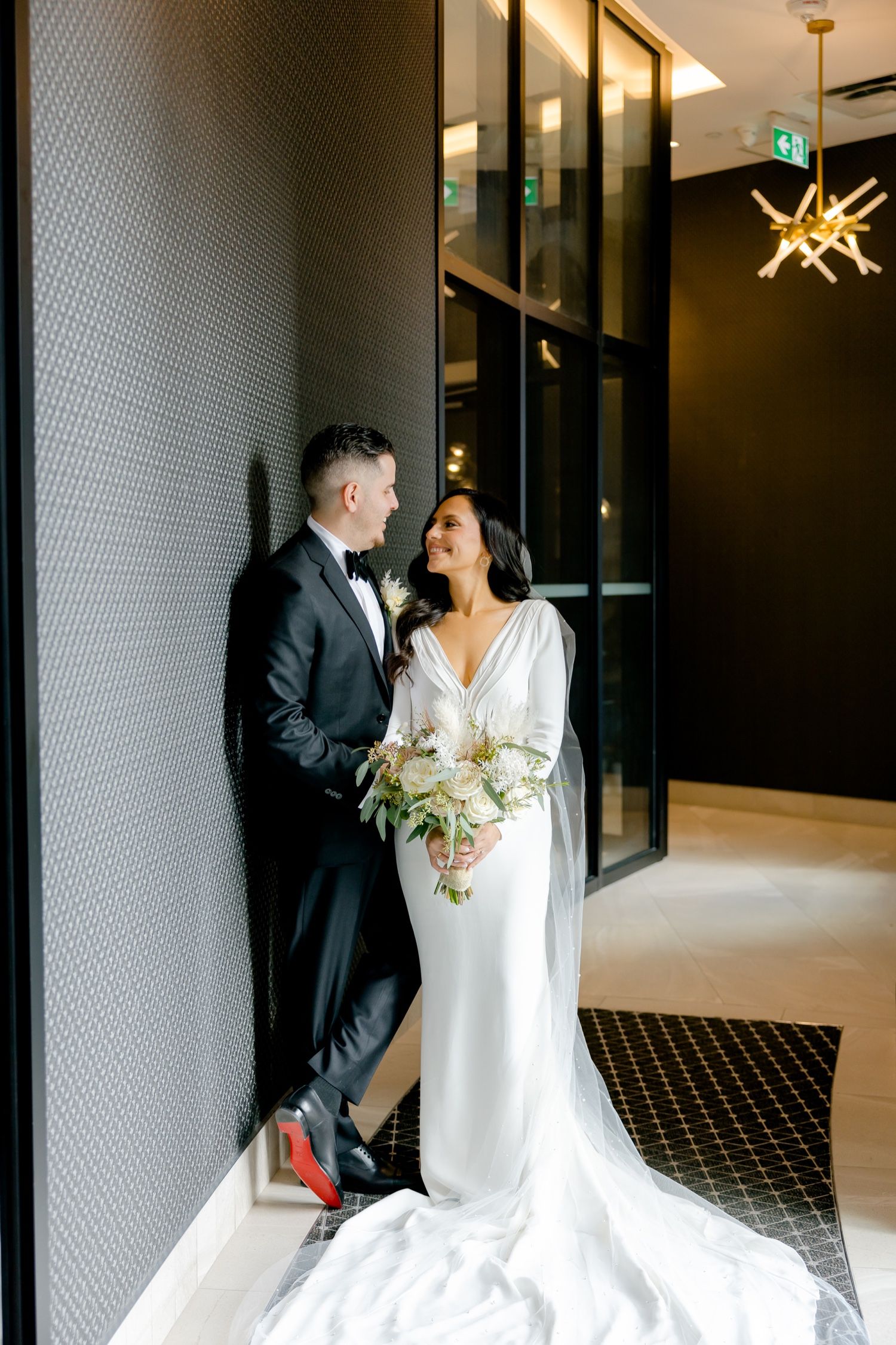 Contemporary wedding portrait against textured wall with dramatic star-shaped ceiling light.