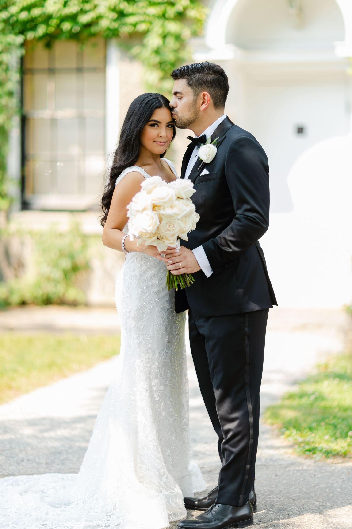 Wedding couple sharing an intimate moment in front of a historic ivy-covered building.