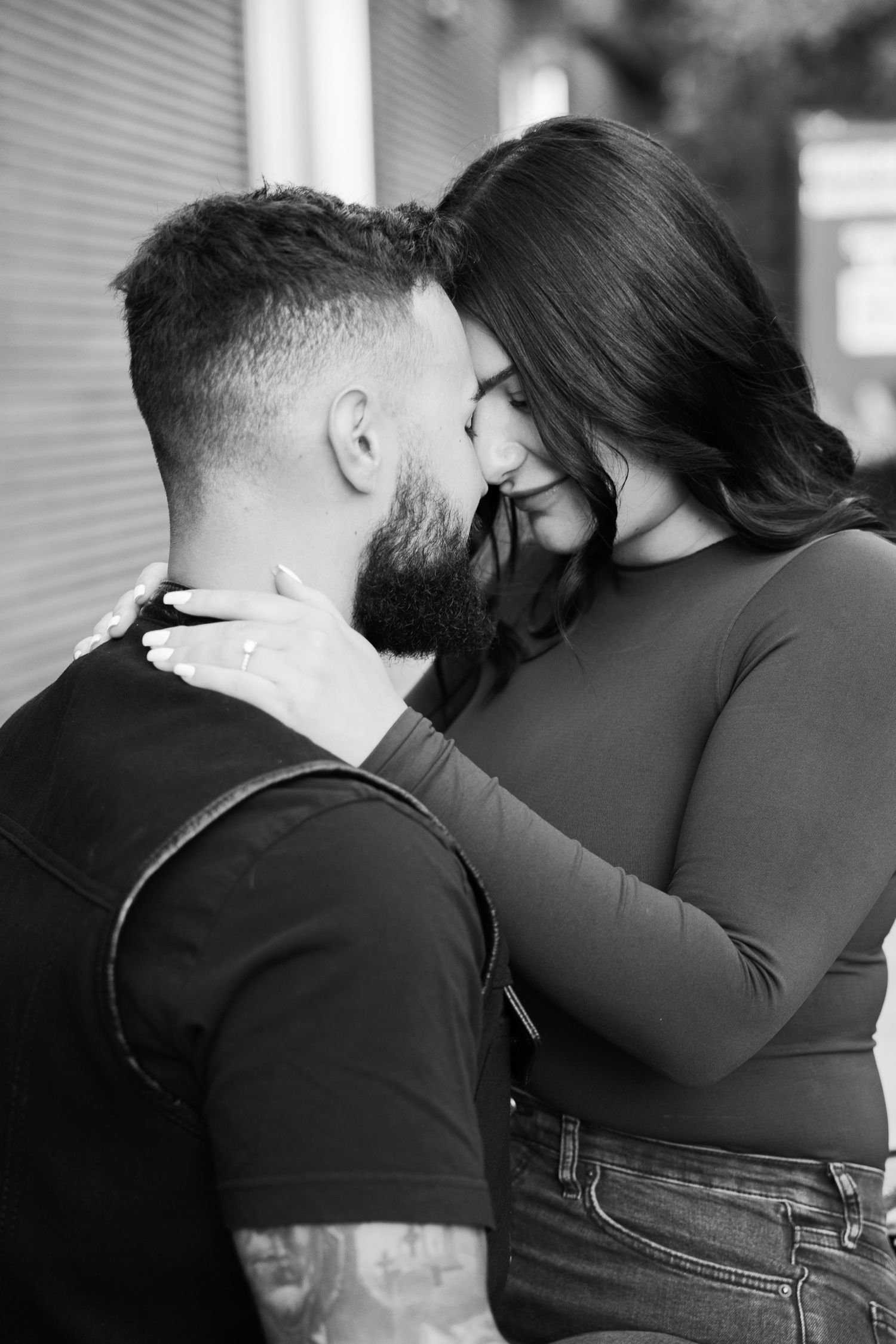 An intimate black and white portrait of a couple sharing a tender moment.