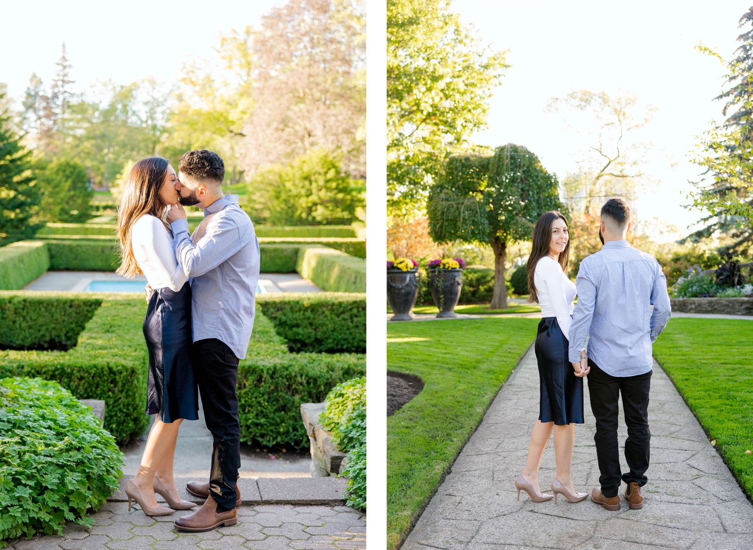 A romantic couple embraces in a formal garden with manicured hedges on a sunny afternoon.