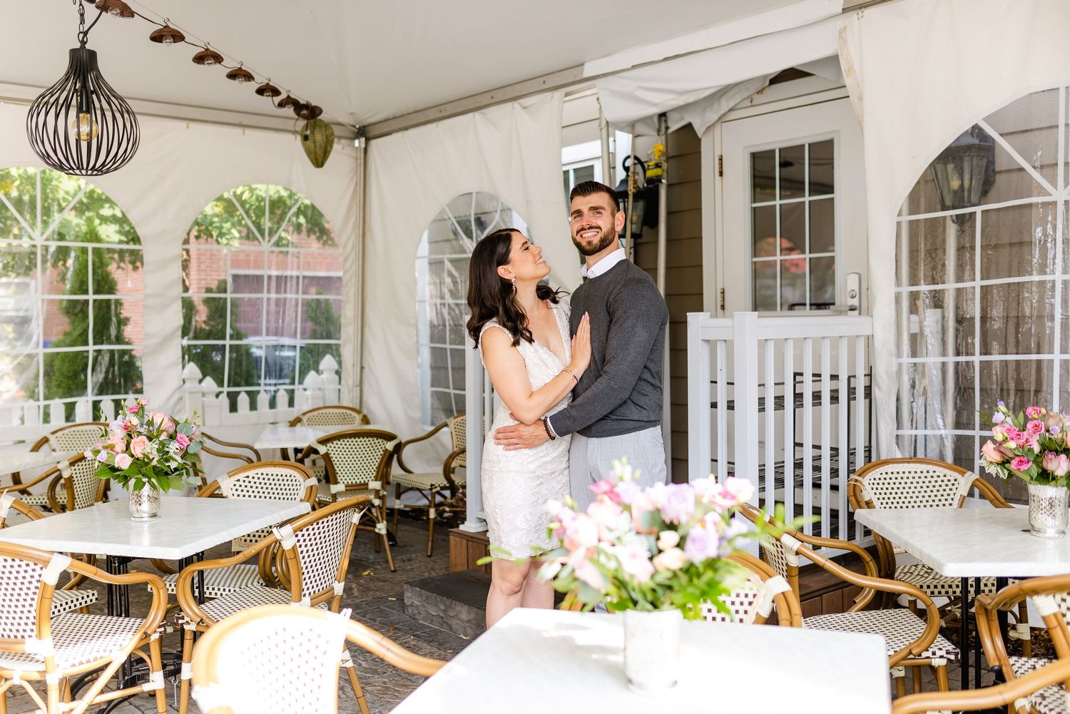A romantic moment captured in a charming restaurant patio setting with bistro tables.
