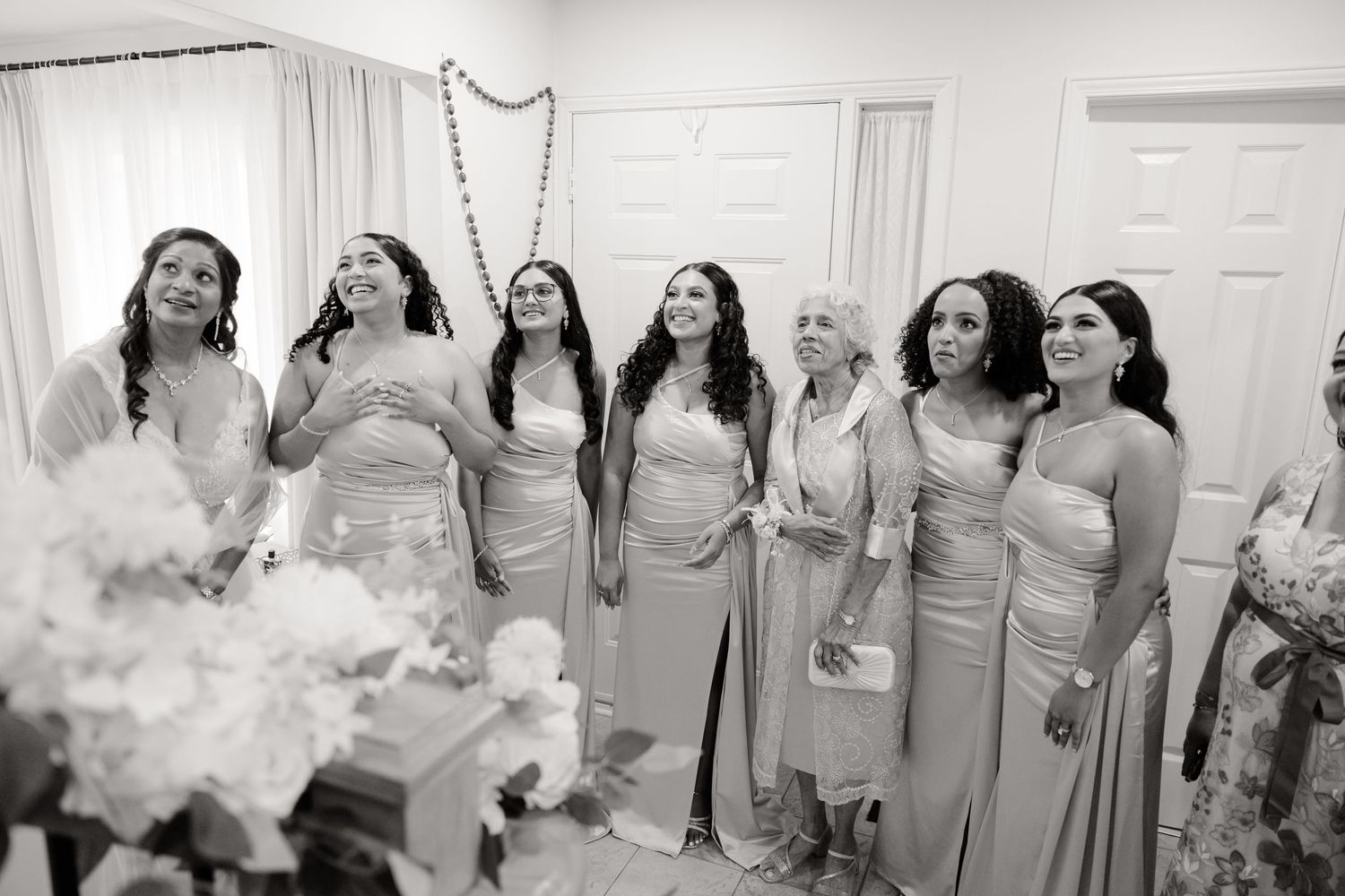 Bridesmaids in matching dresses share a joyful moment together during wedding preparations.