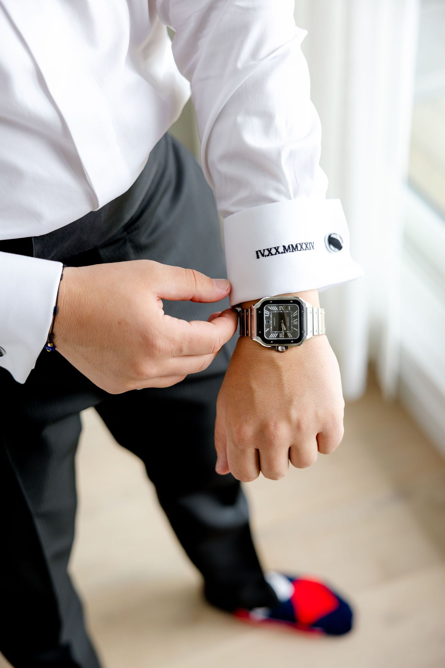 Close-up of a groom checking his digital watch while wearing a formal white dress shirt.