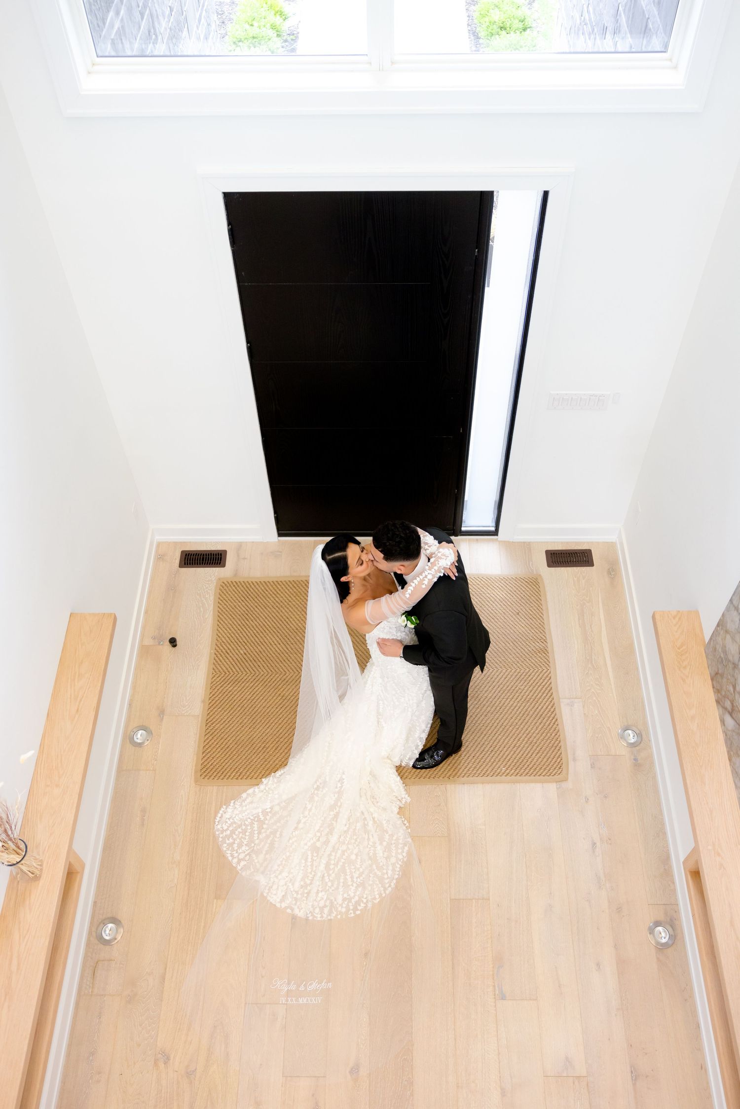 Aerial view of newlyweds dancing together on a wooden floor under skylights.
