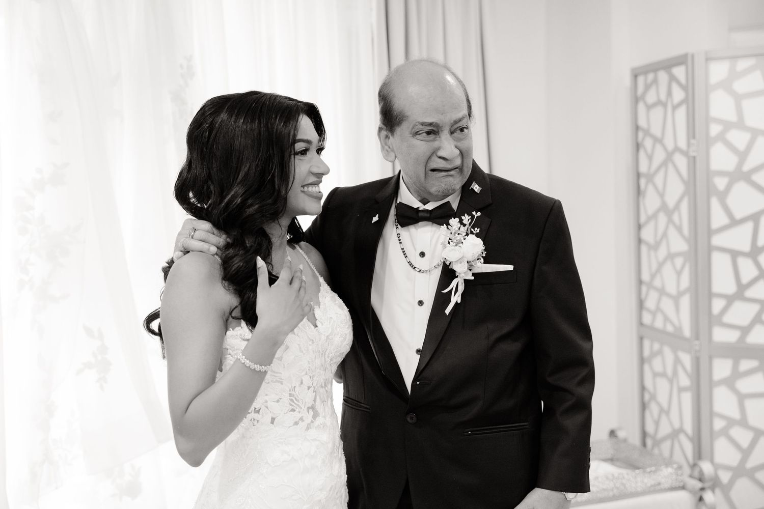 Black and white portrait showing a touching moment between loved ones on a wedding day.