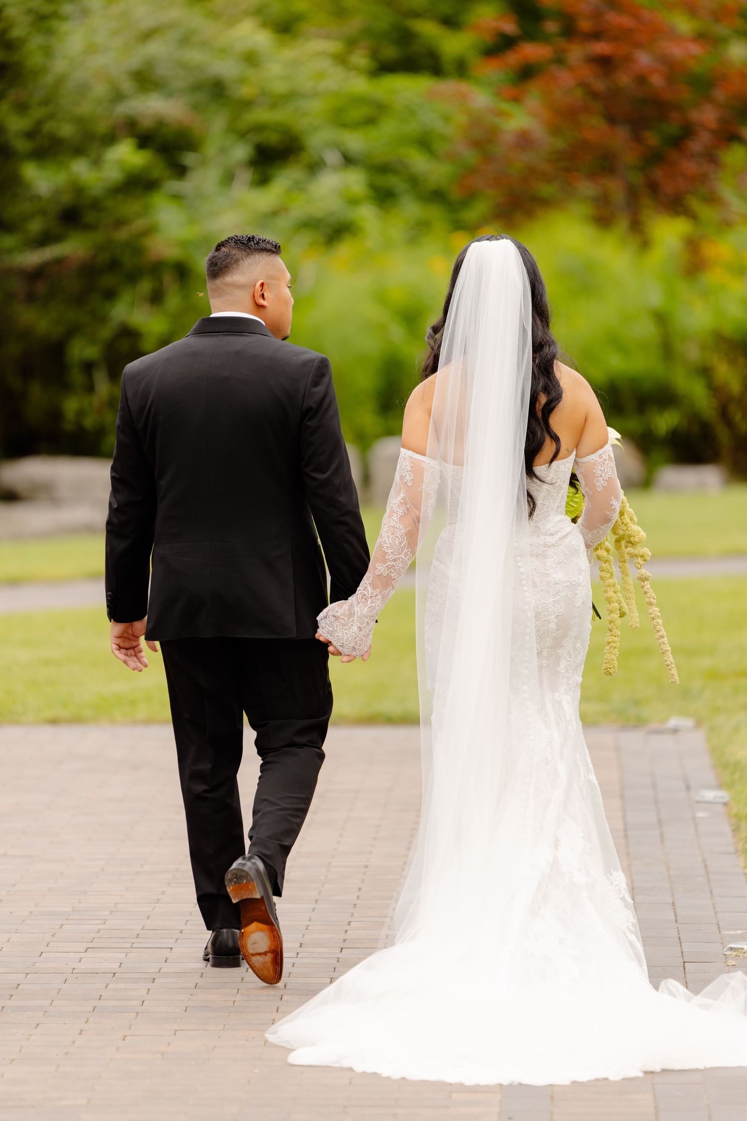 Sequence of photos showing newlyweds walking together on stone path in garden setting with flowing white wedding dress.