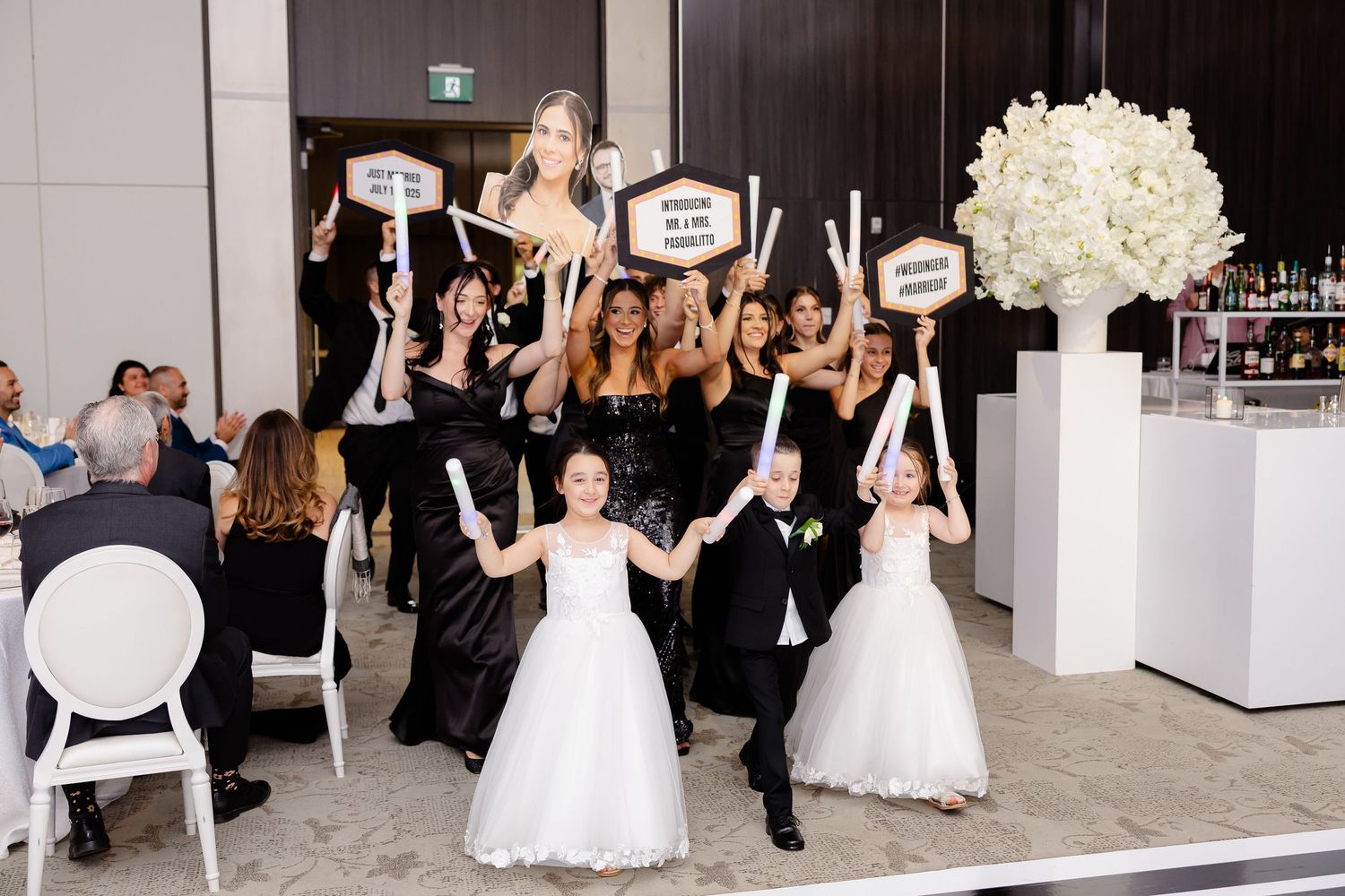 Wedding party performs a choreographed dance routine in the reception hall with audience members watching.