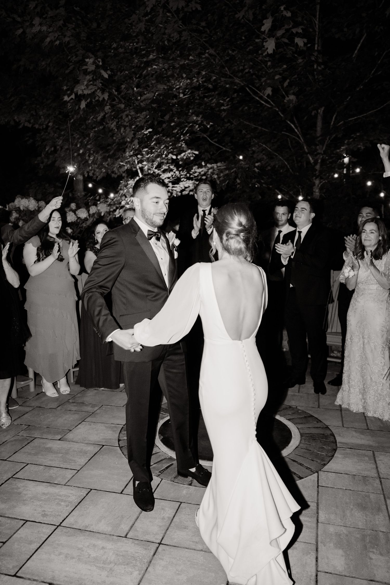 A black and white capture of a couple dancing at their evening wedding reception.