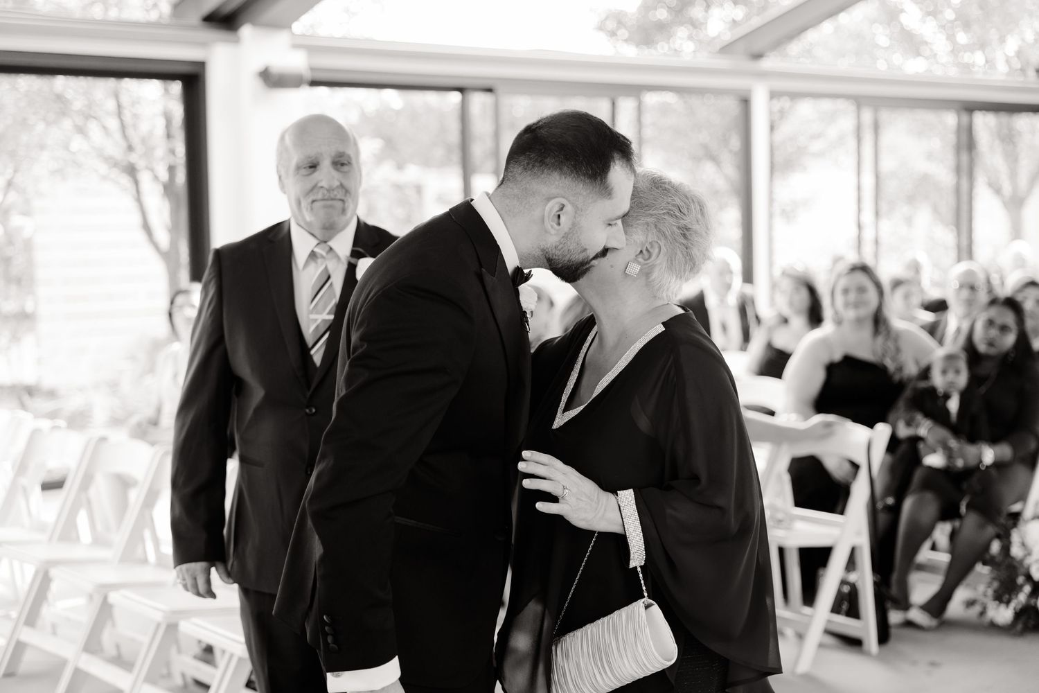 An emotional black and white moment captured during a wedding ceremony processional.