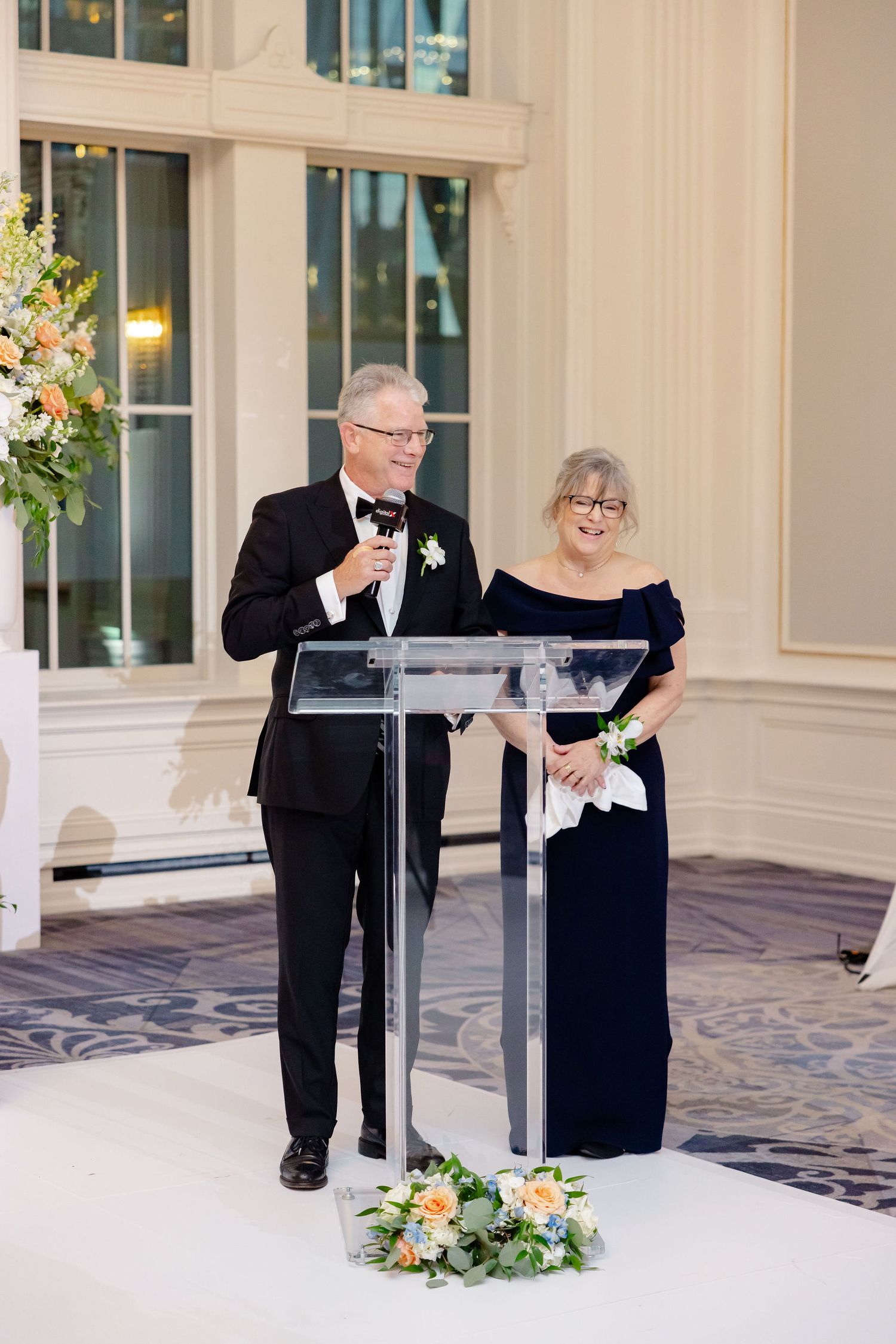 Formal event setup with podium and floral arrangements in an elegant ballroom.