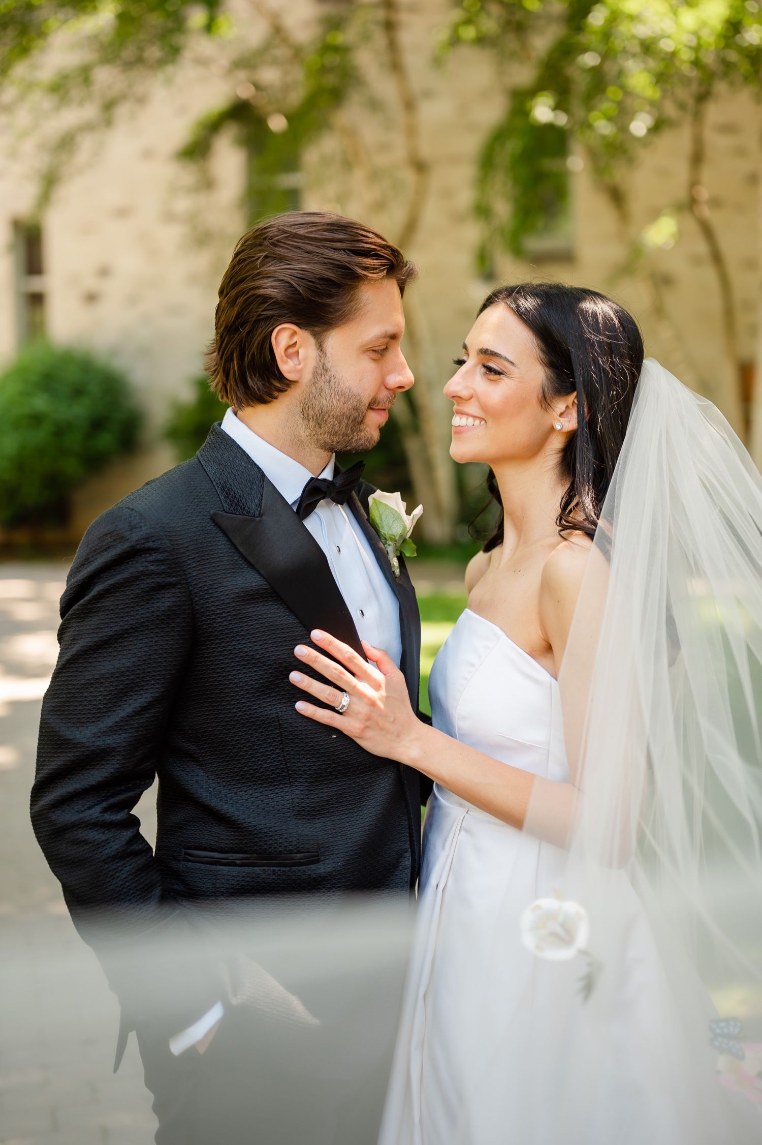 Intimate close-up of wedding couple sharing tender moment under tree branches.