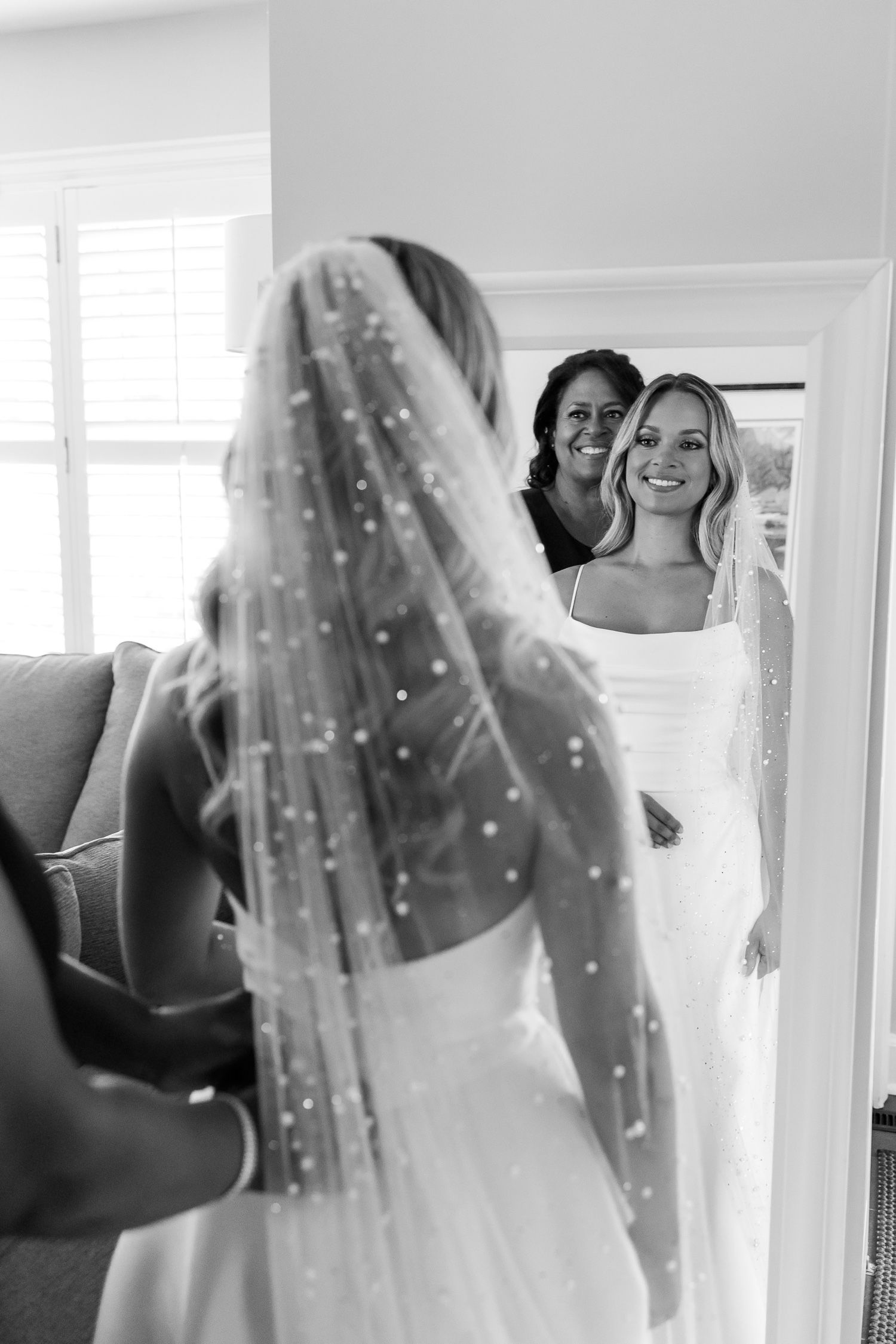 Wedding preparation scene captured in mirror reflection with veil details.
