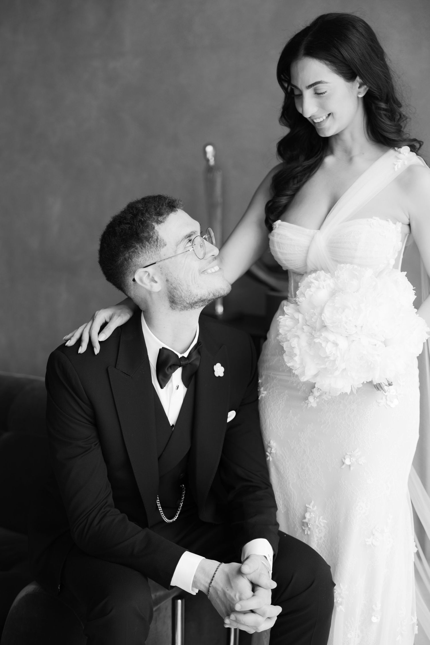 Black and white wedding portrait showcasing intimate moment between couple in formal attire.