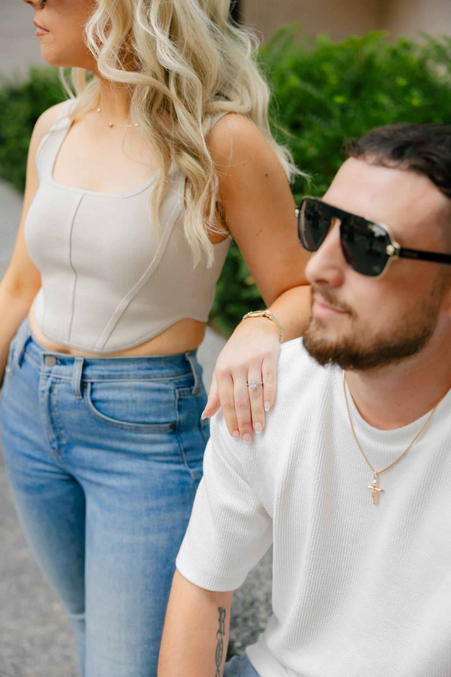 Candid fashion shot of couple in casual summer attire against urban backdrop.
