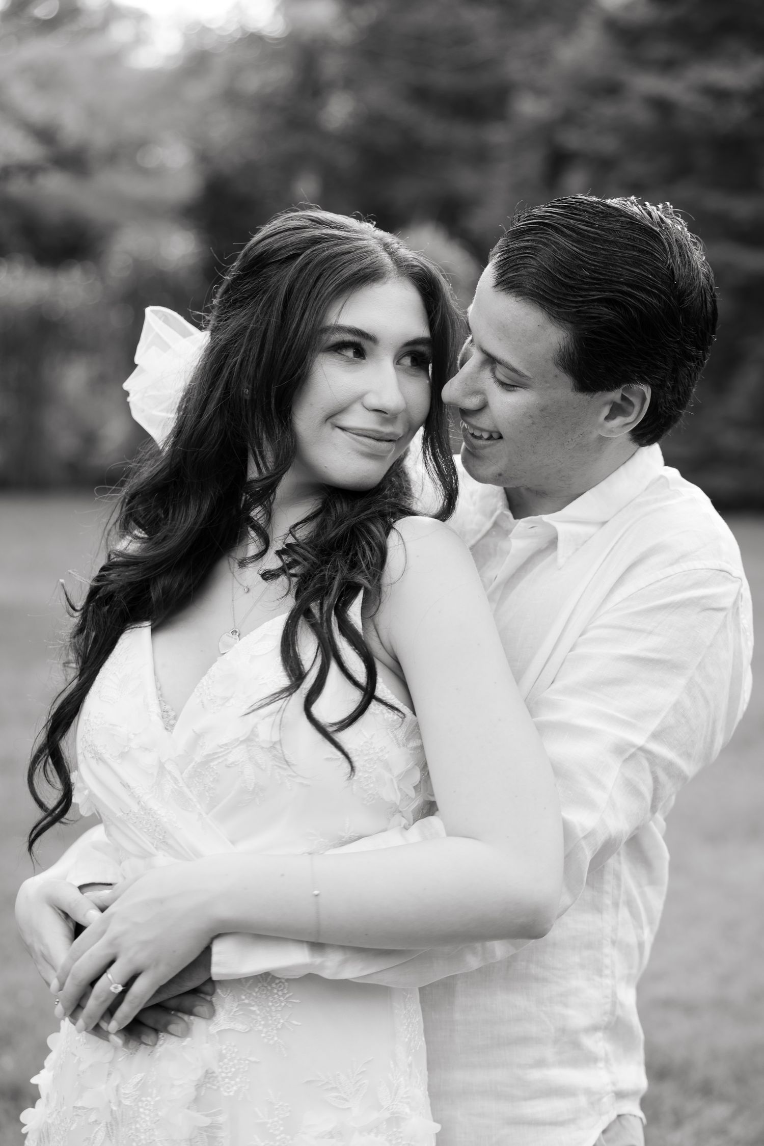 A candid engagement photo showing a couple sharing a sweet moment together outdoors.