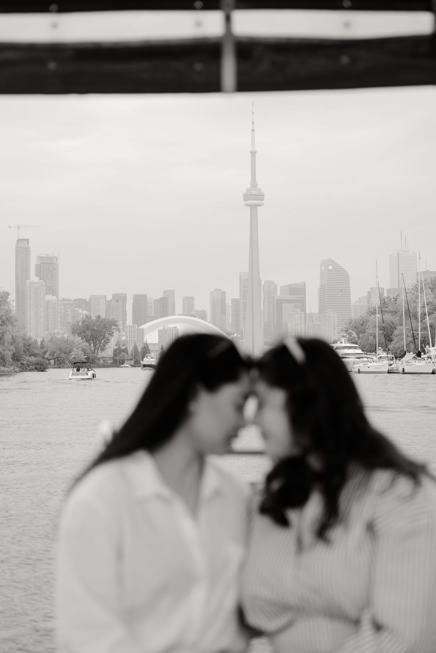 Black and white city view of Toronto's skyline with CN Tower prominently featured over the harbor.