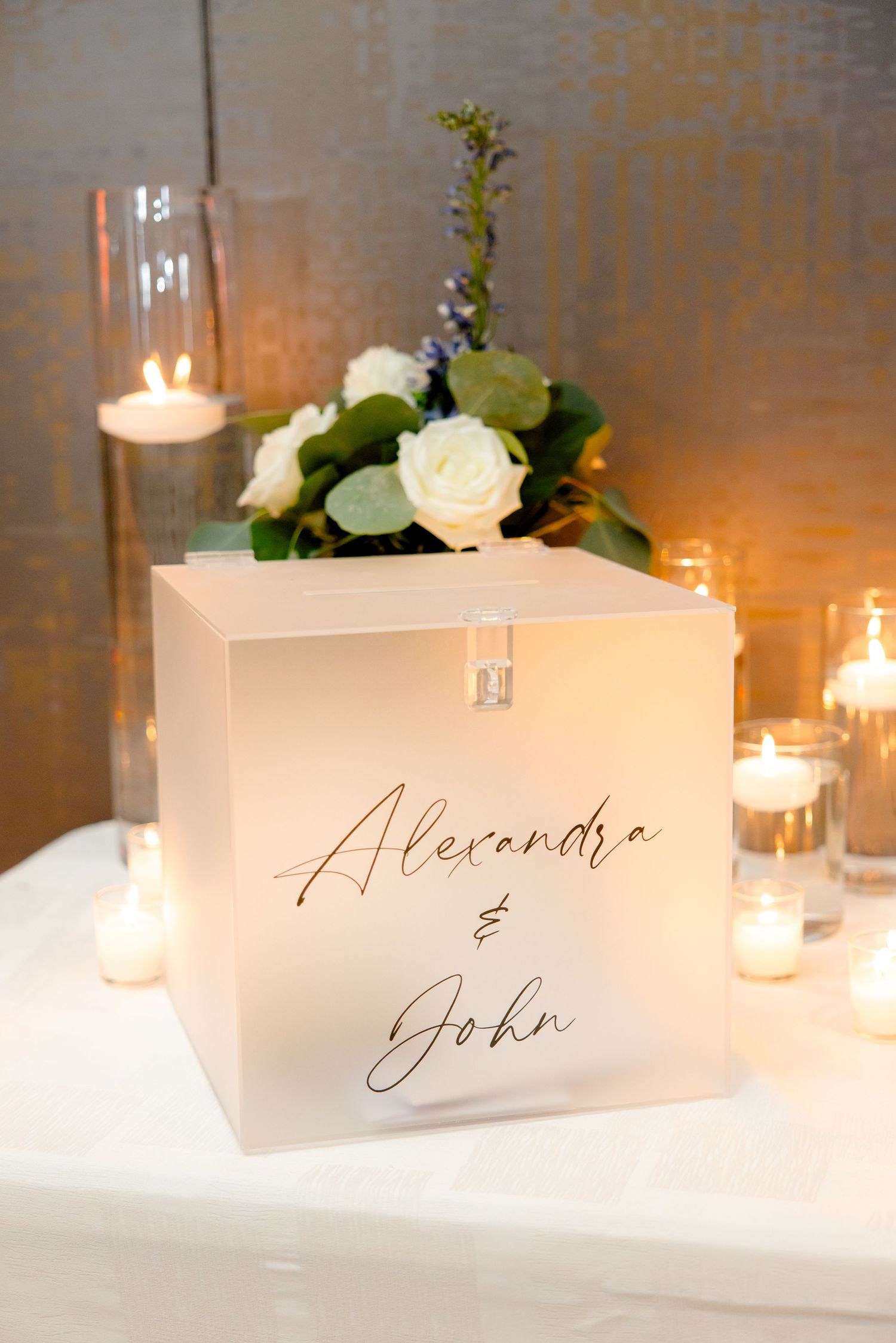 Illuminated wedding card box with white roses and candlelight decor.