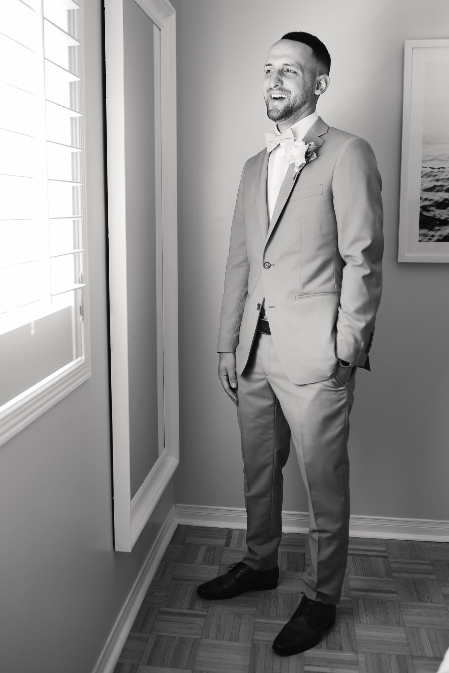 Black and white portrait of a person in a light-colored suit with a boutonniere.