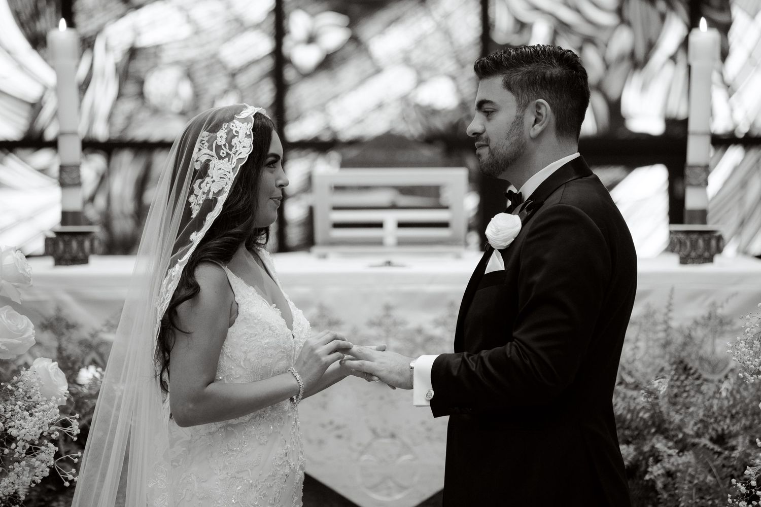 Black and white portrait of a couple during their wedding ceremony exchange.