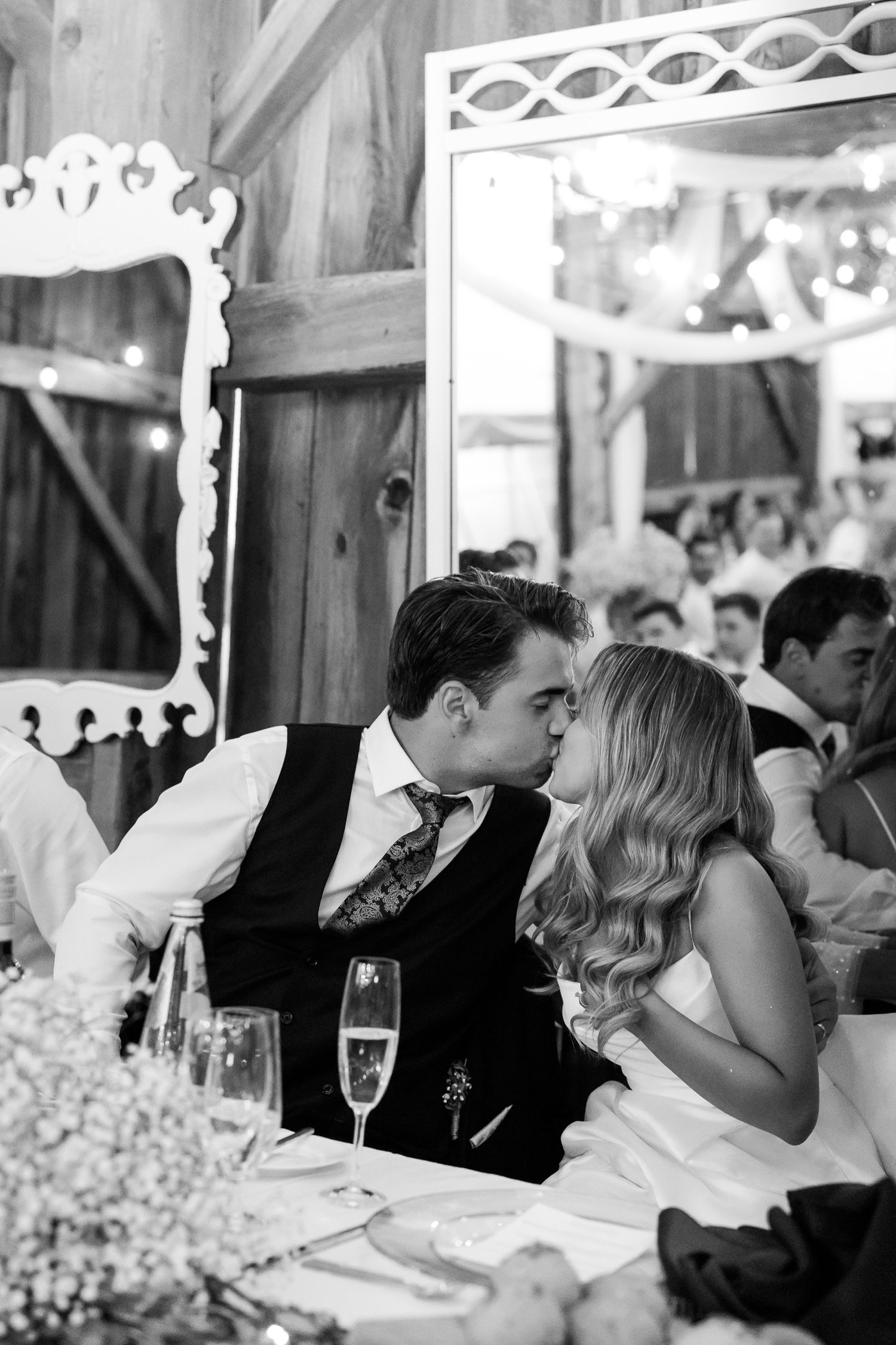 An intimate moment between newlyweds at their reception table with baby's breath decorations.
