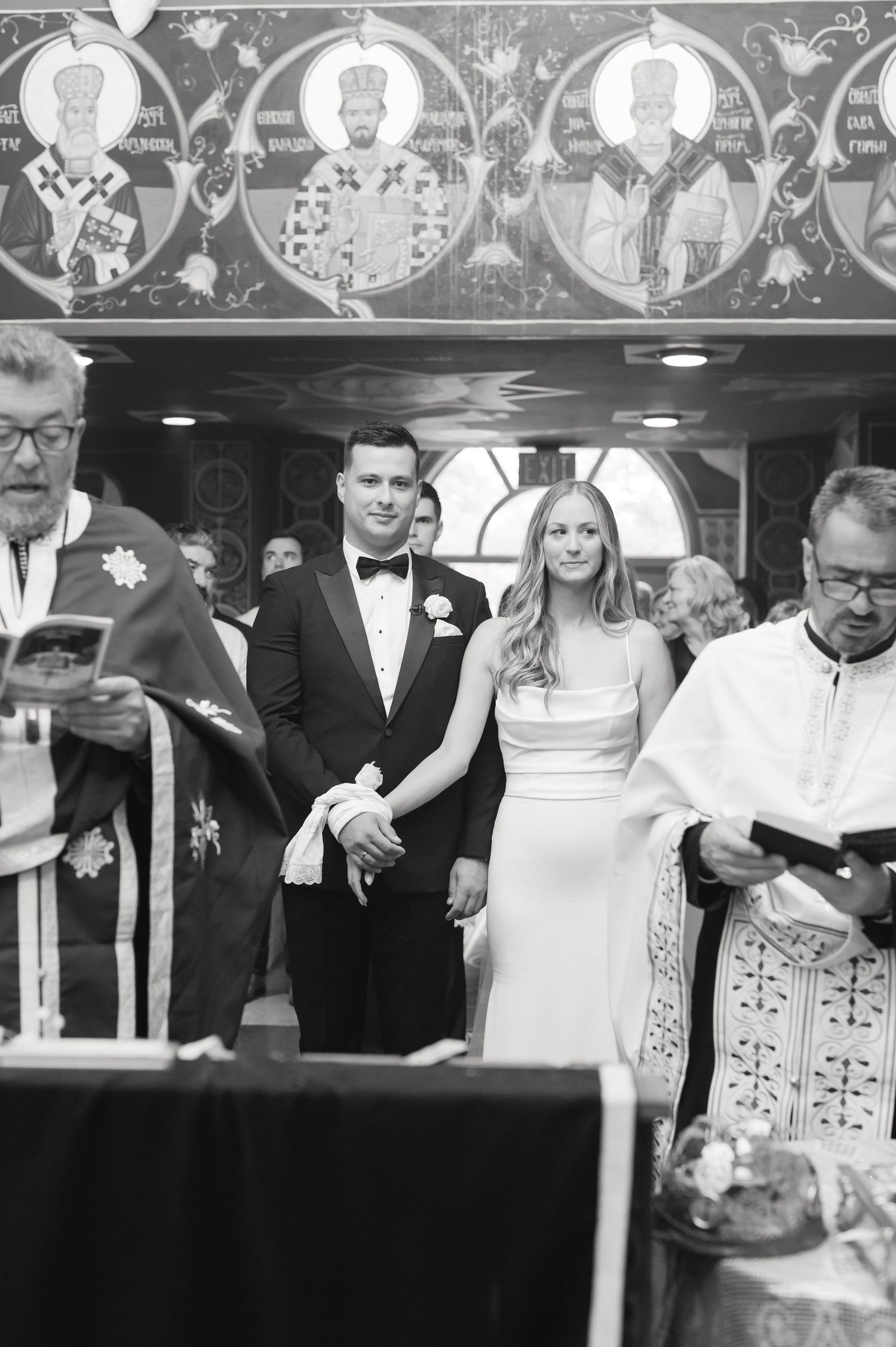 Orthodox wedding ceremony with traditional religious icons visible above the participants.